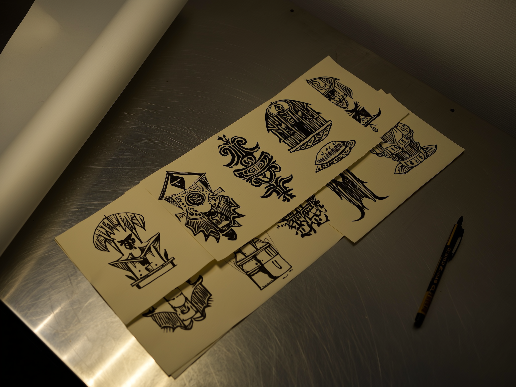 Flashvellen met getekende tattoo-ontwerpen op een metalen werktafel.